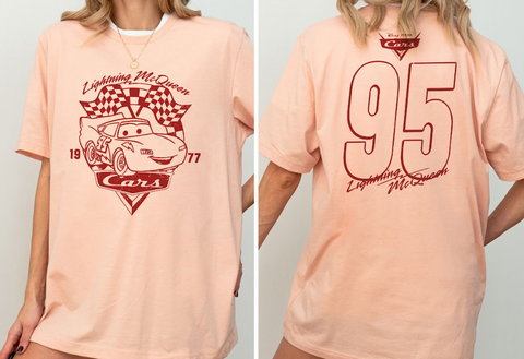 A woman wearing a pink t-shirt with a graphic of Lightning McQueen from the Cars movie, along with the number 95.