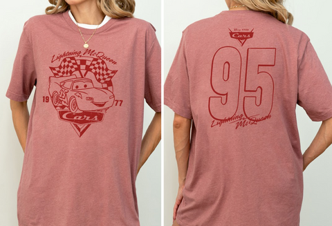 A woman wearing a pink t-shirt with a graphic of Lightning McQueen from the Cars movie, along with the number 95.