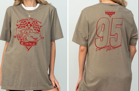 A woman wearing a grey t-shirt with a red graphic design featuring a car and the text "Lightning McQueen" and "95".