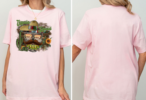 A woman wearing a pink t-shirt with a graphic design featuring a sombrero, cactus, sunflower, and other Mexican-themed elements.