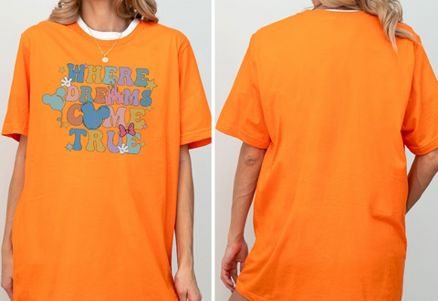 a person wearing an orange t-shirt with a colorful graphic and text on it.