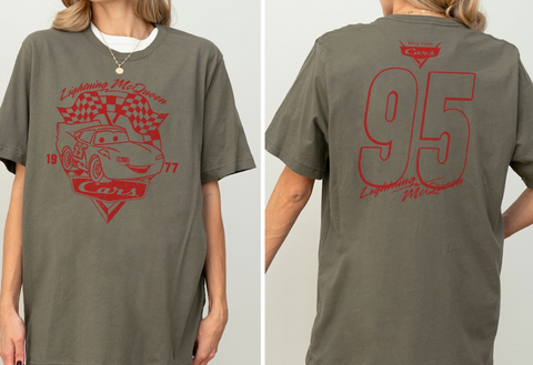 A gray t-shirt with a red graphic design featuring a car and the text "Lightning McQueen" and "Cars" printed on it.