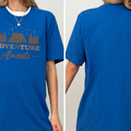 A woman wearing a blue t-shirt with the text "Adventure Awaits" printed on it.