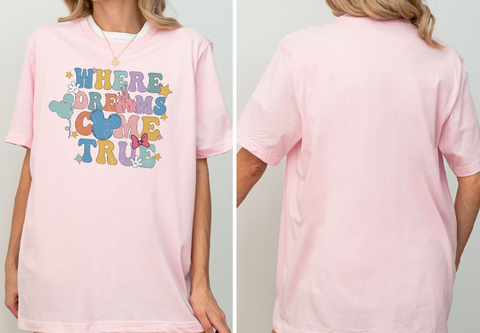 A woman wearing a pink t-shirt with the text "WHERE DREAMS COME TRUE" printed on it.