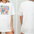 A white t-shirt with a colorful graphic design featuring the text "WHERE DREAMS COME TRUE" and a Mickey Mouse character.