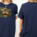 A woman wearing a navy blue t-shirt with a graphic design featuring a sombrero, cactus, and sunflowers.