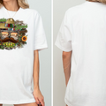 A white t-shirt with a graphic design featuring a skull wearing a sombrero and sunglasses, surrounded by various Mexican-themed elements such as cacti, flowers, and a sunflower.