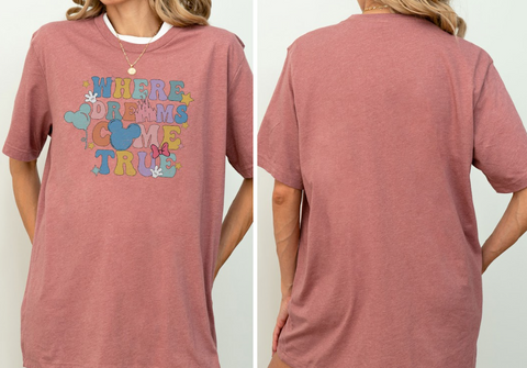 A woman wearing a pink t-shirt with a Disney-themed graphic and text.