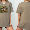 A woman wearing a gray t-shirt with a graphic design featuring a sombrero, cactus, and other Mexican-themed elements.