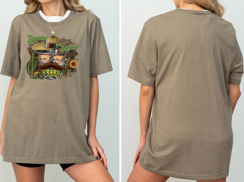 A woman wearing a gray t-shirt with a graphic design featuring a sombrero, cactus, and other Mexican-themed elements.