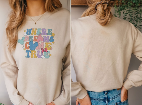 A woman wearing a white sweatshirt with a Disney-themed design and text.
