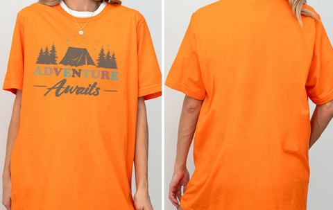 a person wearing an orange t-shirt with the text "Adventure Awaits" printed on it.